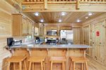 Kitchen with granite counter tops, electric appliances and bar seating for 4